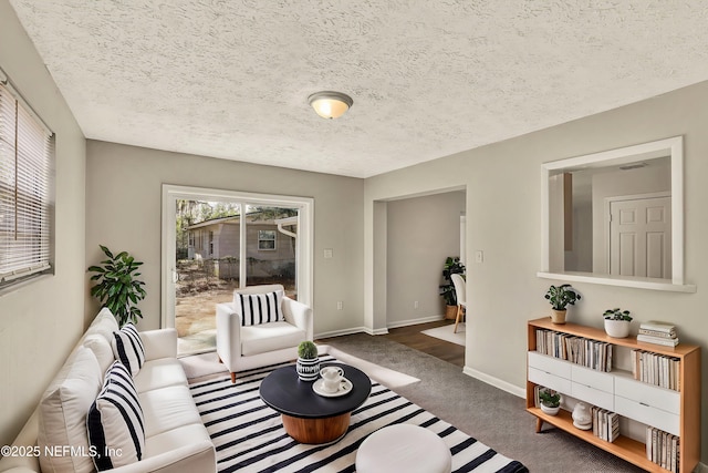 living room with a textured ceiling and dark carpet