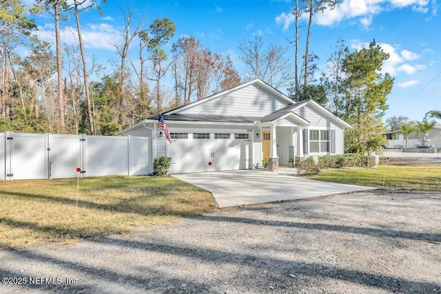 ranch-style house featuring a garage, concrete driveway, a gate, fence, and a front yard