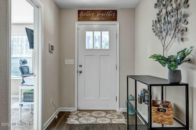 foyer with a wealth of natural light, dark wood finished floors, and baseboards