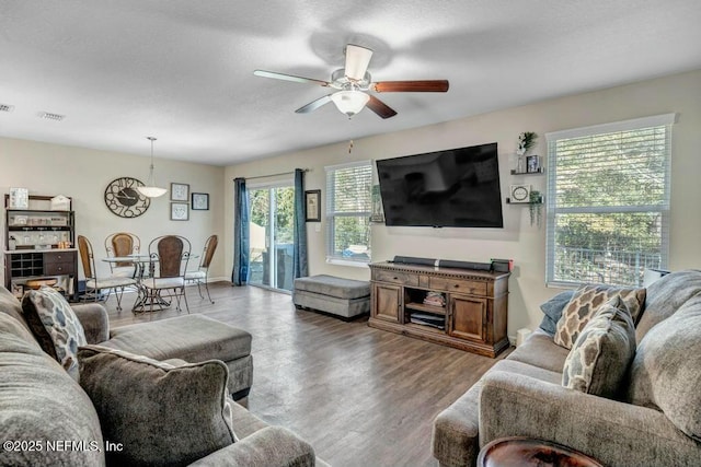 living area with ceiling fan, light wood finished floors, and visible vents