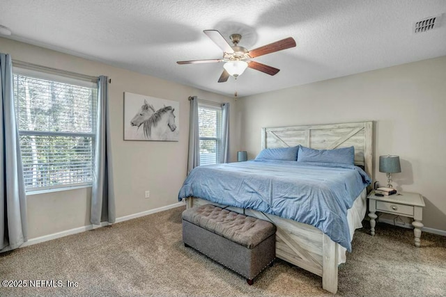 bedroom featuring carpet floors, visible vents, a textured ceiling, and baseboards