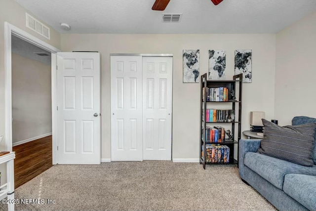 sitting room with ceiling fan, carpet floors, visible vents, and baseboards