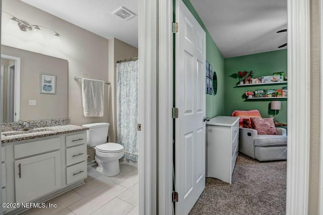 bathroom featuring toilet, vanity, and visible vents