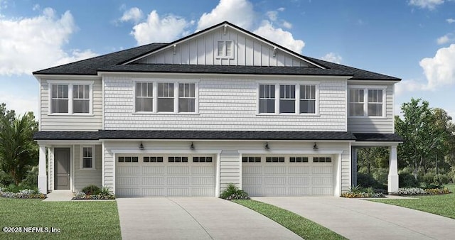 view of front of house with driveway, an attached garage, board and batten siding, and a front yard