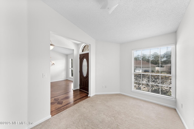 carpeted empty room featuring a textured ceiling