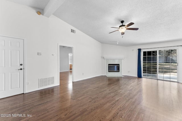 unfurnished living room with lofted ceiling with beams, a premium fireplace, ceiling fan, and dark hardwood / wood-style flooring