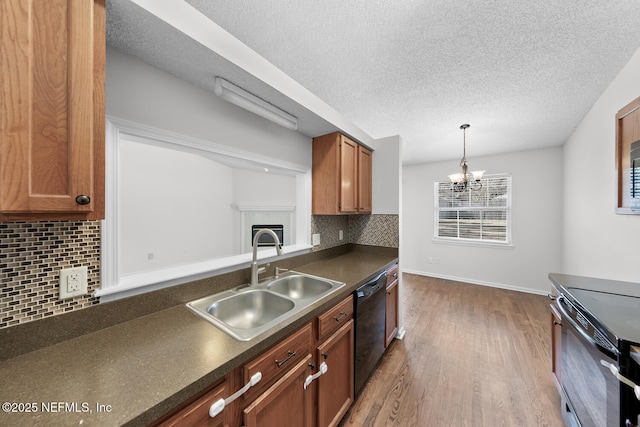 kitchen featuring sink, electric range oven, dishwasher, a tiled fireplace, and hardwood / wood-style floors