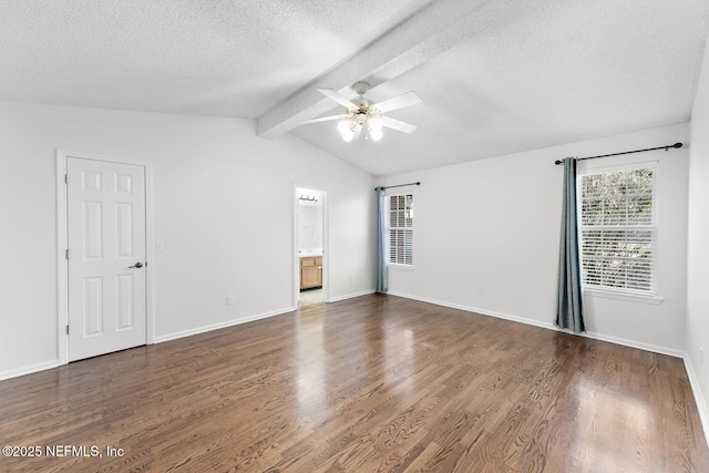 unfurnished room with ceiling fan, dark wood-type flooring, vaulted ceiling with beams, and a healthy amount of sunlight