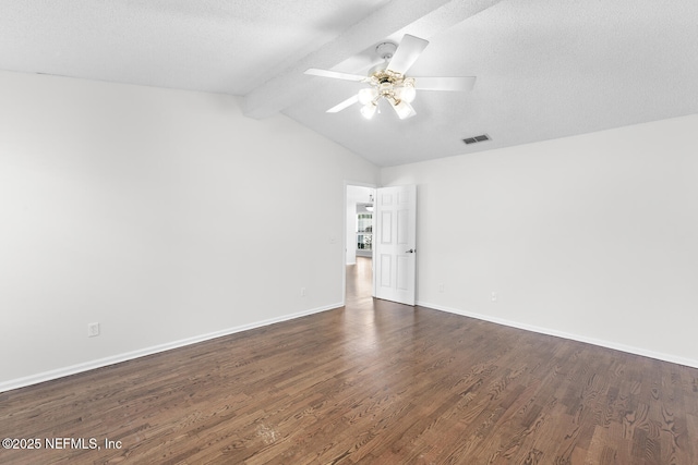 empty room featuring dark hardwood / wood-style flooring, vaulted ceiling with beams, and a textured ceiling