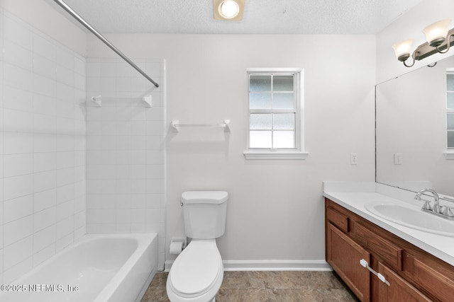 full bathroom with vanity, toilet, tiled shower / bath combo, and a textured ceiling