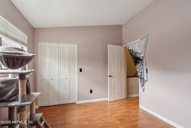 bedroom with a closet, a textured ceiling, and light wood-type flooring