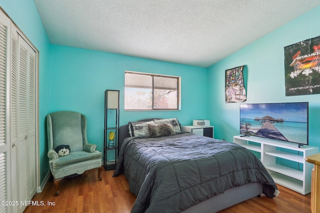 bedroom with hardwood / wood-style flooring, a closet, and a textured ceiling