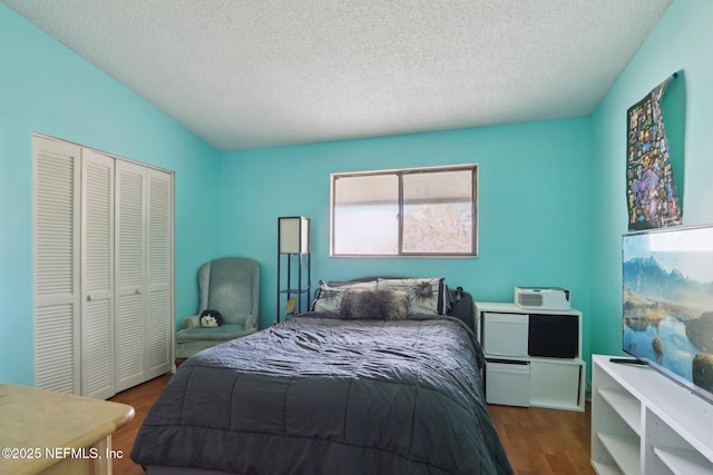 bedroom featuring hardwood / wood-style flooring, a textured ceiling, and a closet