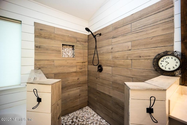 bathroom with wood walls and a tile shower