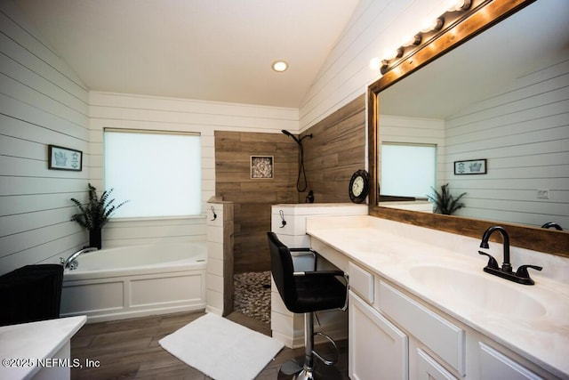 bathroom featuring vaulted ceiling, vanity, a bathtub, and hardwood / wood-style floors