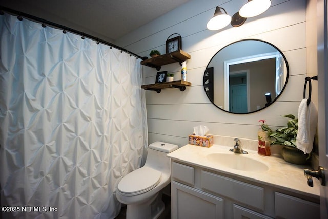 bathroom featuring vanity, walk in shower, and toilet