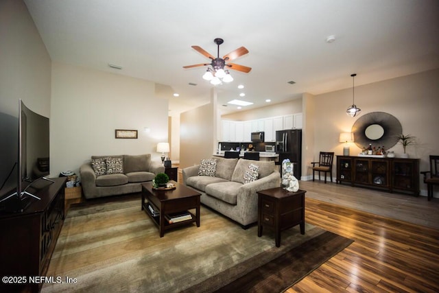 living room featuring dark wood-type flooring and ceiling fan