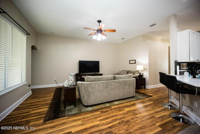 living room featuring ceiling fan and dark hardwood / wood-style floors