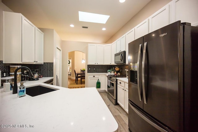 kitchen featuring white cabinetry, sink, tasteful backsplash, and black appliances