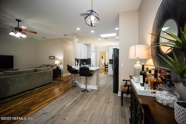 interior space with ceiling fan and light hardwood / wood-style flooring