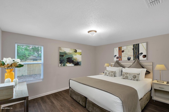 bedroom featuring dark hardwood / wood-style flooring and a textured ceiling