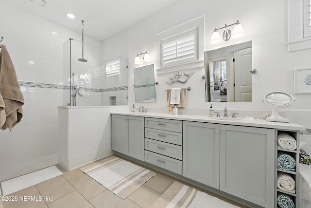 full bath with tile patterned flooring, a walk in shower, a sink, and double vanity