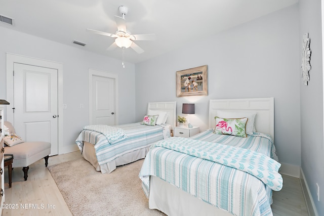 bedroom with visible vents, ceiling fan, baseboards, and wood finished floors