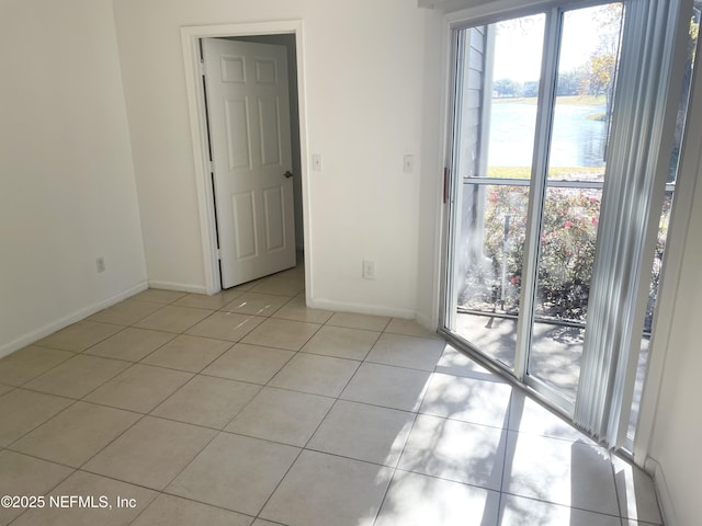 tiled spare room with a water view