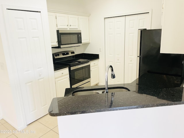 kitchen with sink, light tile patterned floors, appliances with stainless steel finishes, white cabinets, and kitchen peninsula