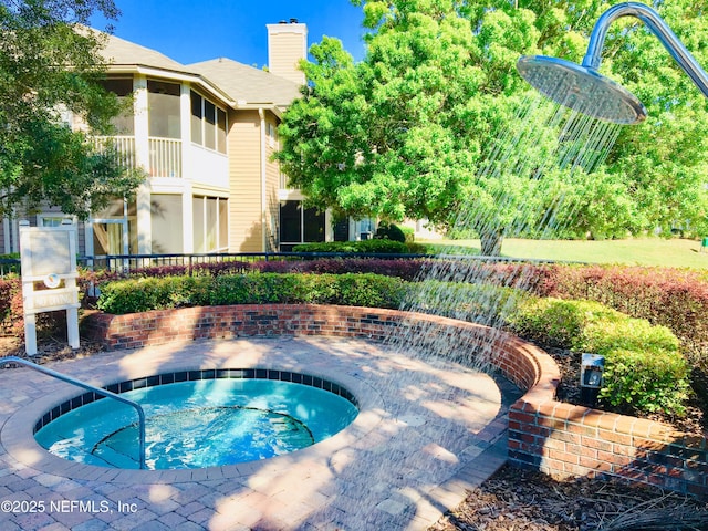 view of pool with an in ground hot tub