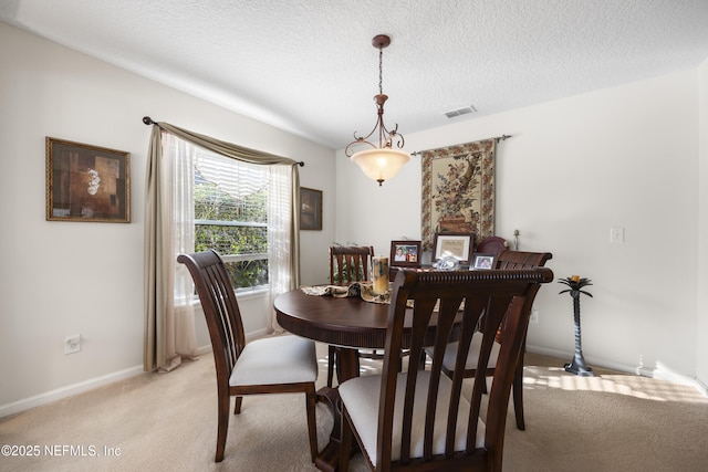 carpeted dining area featuring a textured ceiling