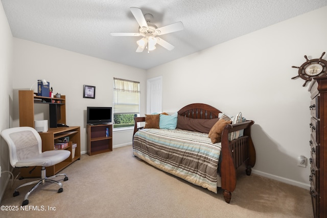 bedroom with ceiling fan, light colored carpet, and a textured ceiling