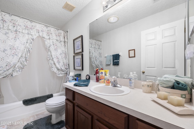 full bathroom with tile patterned floors, toilet, a textured ceiling, vanity, and shower / bath combo with shower curtain