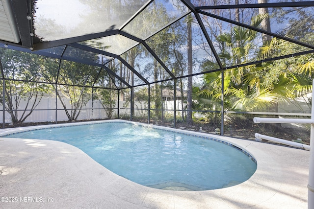 view of pool with a patio and glass enclosure