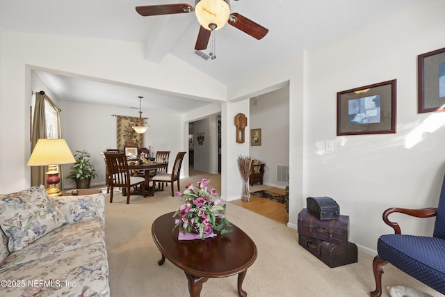 carpeted living room with ceiling fan, lofted ceiling with beams, and a textured ceiling