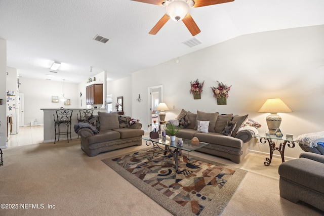 living room featuring lofted ceiling, light colored carpet, and ceiling fan