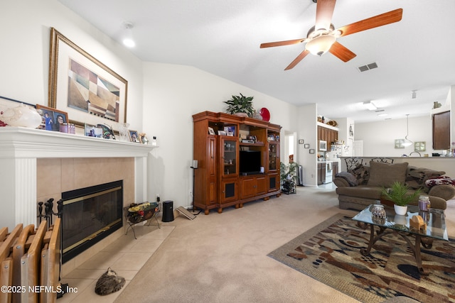 carpeted living room featuring a tile fireplace, vaulted ceiling, radiator heating unit, and ceiling fan