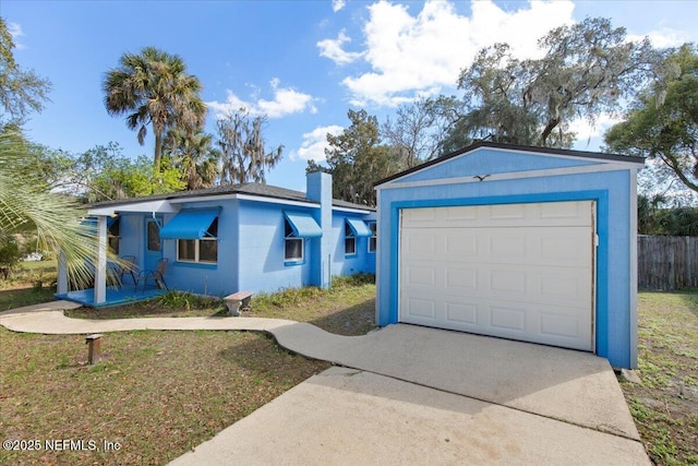 ranch-style home featuring a garage, concrete block siding, a front lawn, and concrete driveway