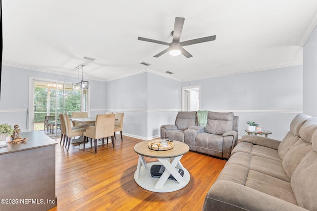 living room with light hardwood / wood-style flooring and ornamental molding