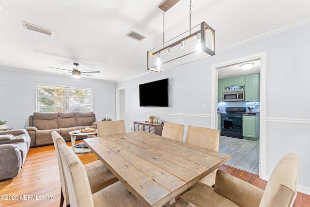 dining room featuring crown molding, ceiling fan, and light hardwood / wood-style floors