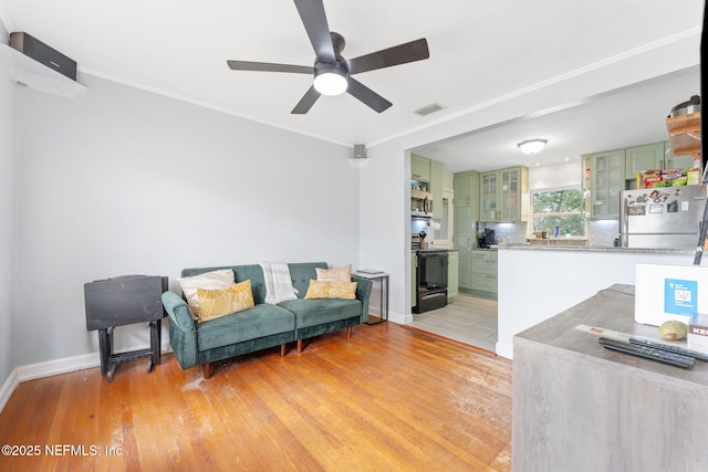 living room with crown molding, light hardwood / wood-style flooring, and ceiling fan