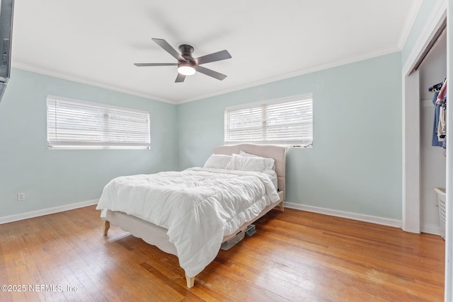 bedroom featuring crown molding, ceiling fan, a closet, and light wood-type flooring