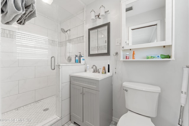 bathroom with vanity, toilet, and a shower with shower door