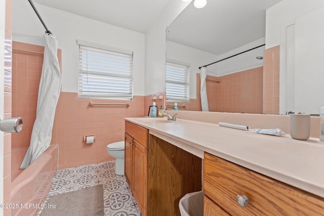 full bathroom featuring tile walls, shower / tub combo, vanity, tile patterned floors, and toilet