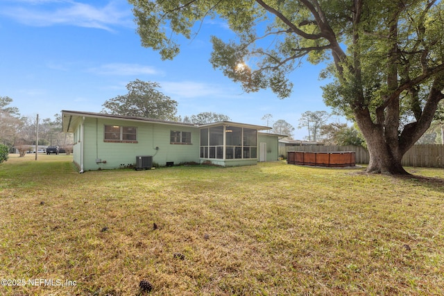 back of house featuring a sunroom, a yard, and cooling unit