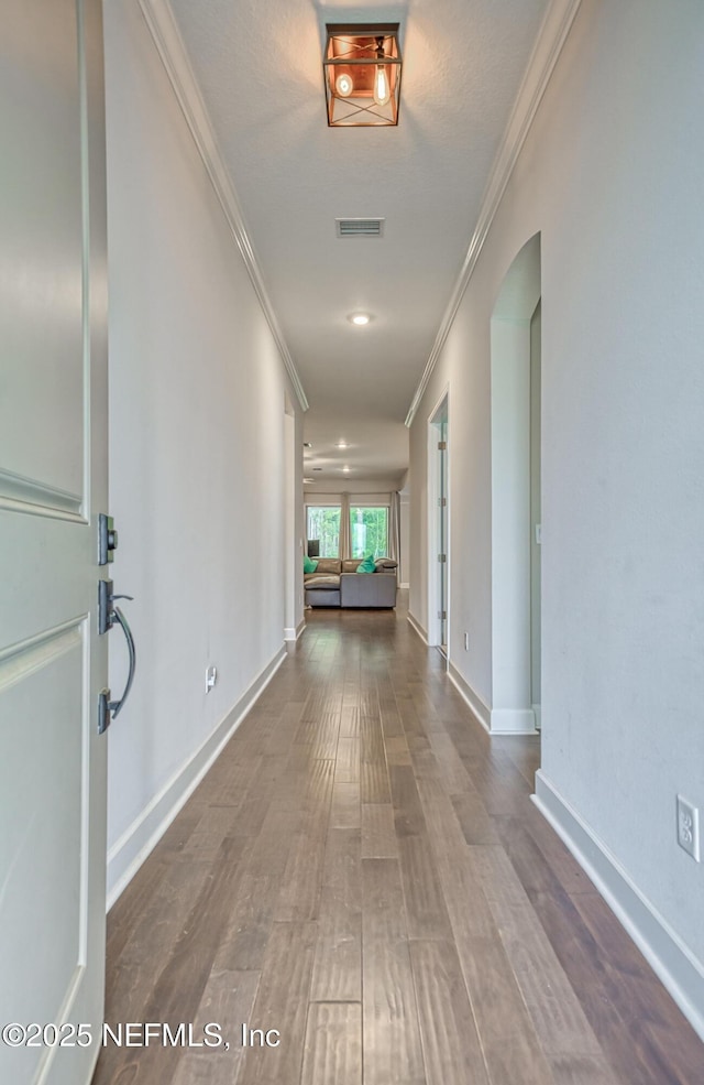 corridor featuring ornamental molding and hardwood / wood-style floors