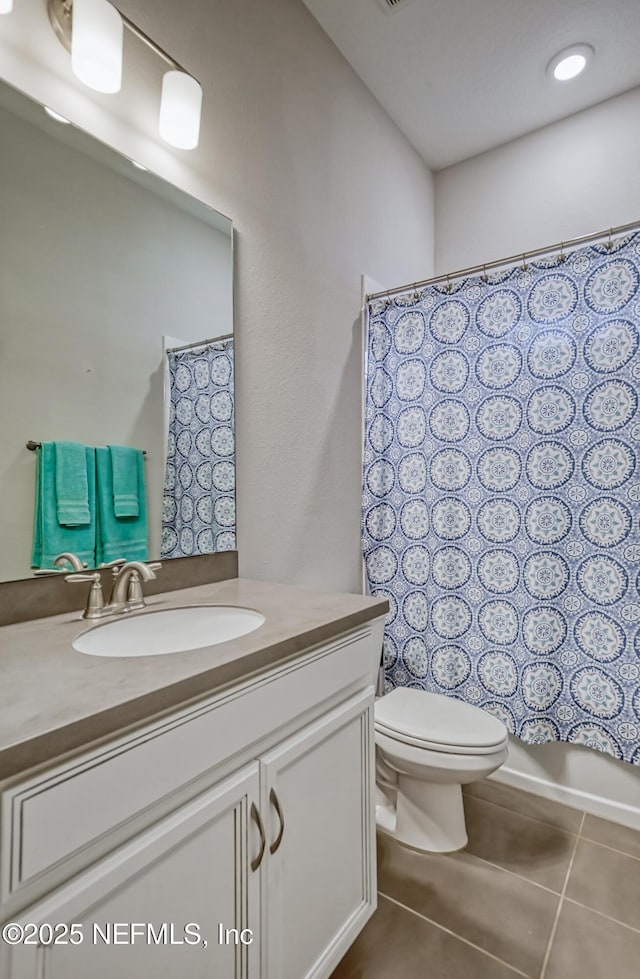 bathroom with tile patterned flooring, vanity, and toilet