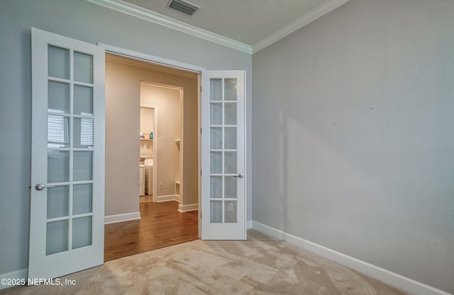 unfurnished room with ornamental molding, french doors, and carpet