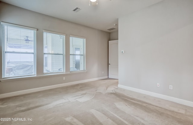 spare room featuring light carpet and ceiling fan