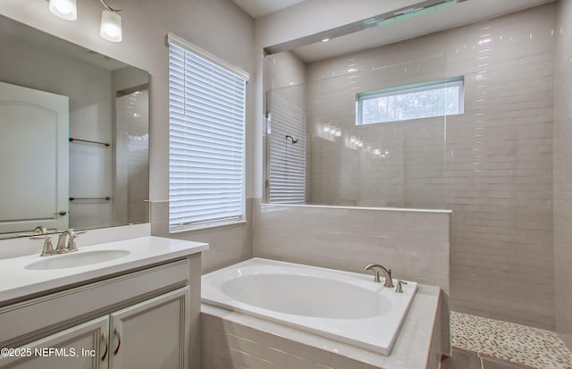 bathroom with vanity and shower with separate bathtub